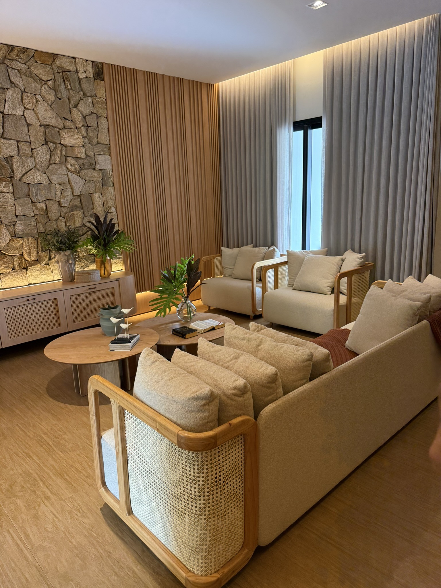 Sala de estar com pedra e poltronas de madeira