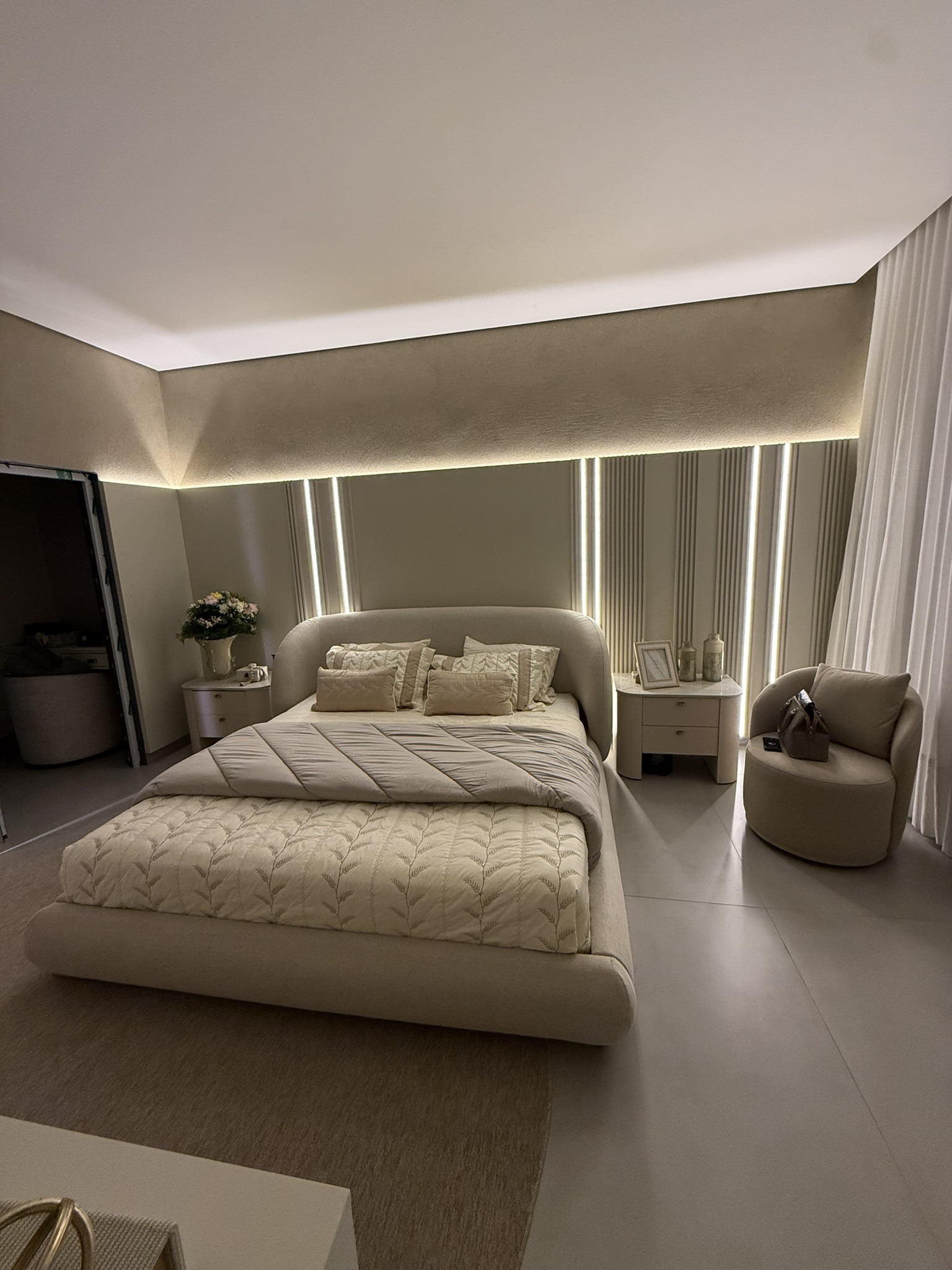 Quarto com cabeceira clara e iluminação vertical